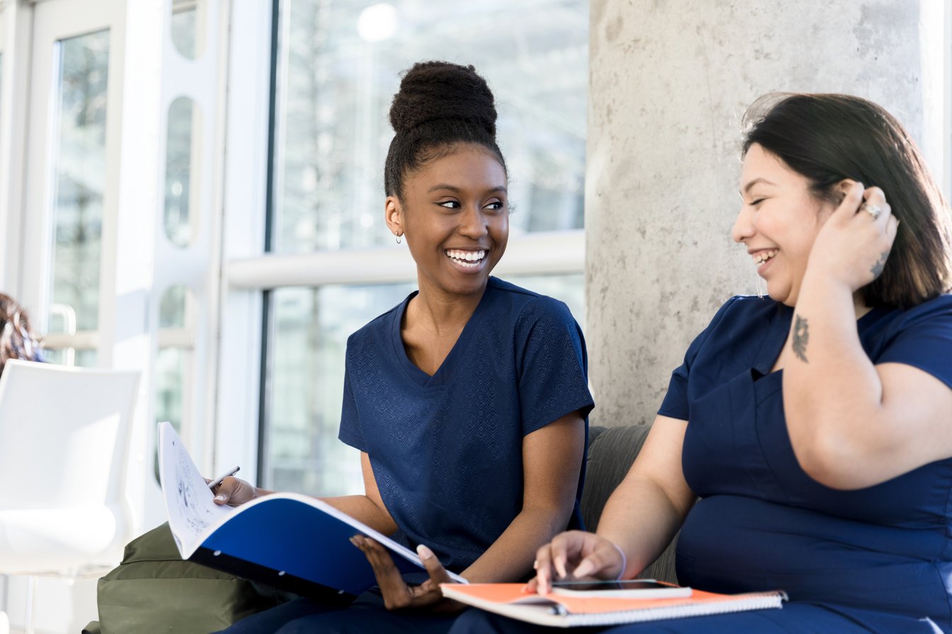 Female nursing students laugh together while studying